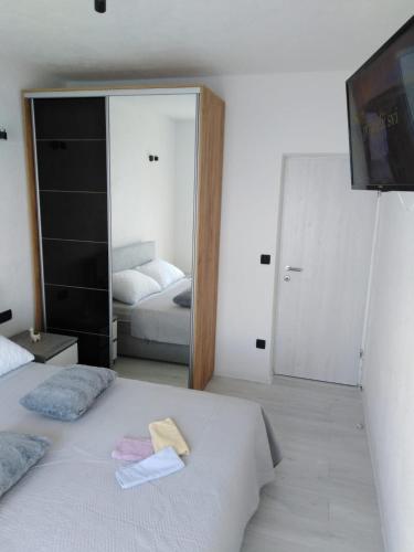 a bedroom with two beds and a mirror at Apartment Anđela in Podgora