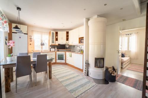 a kitchen and dining room with a table and a fireplace at Aidattu omakotitalo - Palju lisämaksusta in Kalajoki