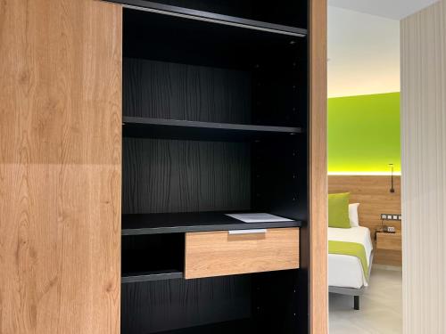 a book shelf with a desk in a room at Hotel MG Poniente in Las Palmas de Gran Canaria
