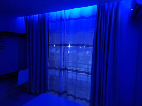 a blue room with a curtain and a window at E2G Meublé 1 CH 2e CH dispo avec supplément in Douala