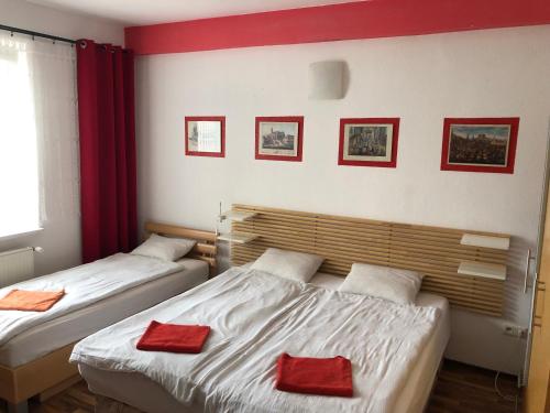 2 Betten in einem Zimmer mit roten Kissen darauf in der Unterkunft Red Apartment in Bratislava