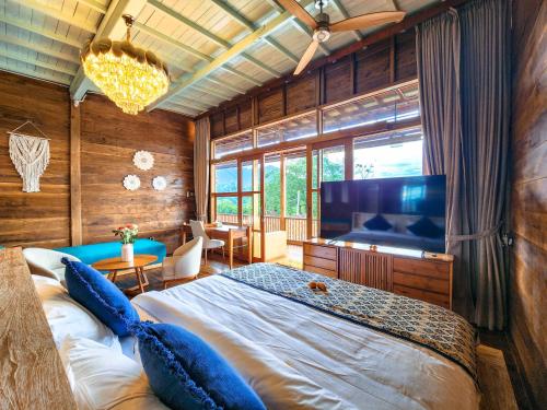 a bedroom with a large bed and a large television at Mountain Healing Villa by Nagisa Bali in Baturiti