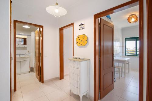 una camera con cucina con bancone e orologio sul muro di Ap np ad Armação de Pêra