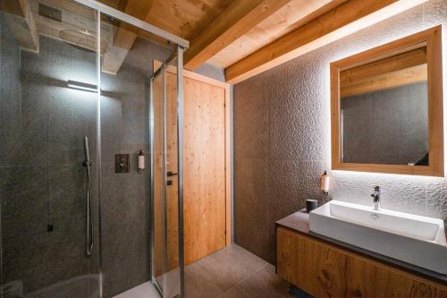 ein Bad mit einer Glasdusche und einem Waschbecken in der Unterkunft DALANIA MOUNTAIN APARTMENTS in Ponte di Legno