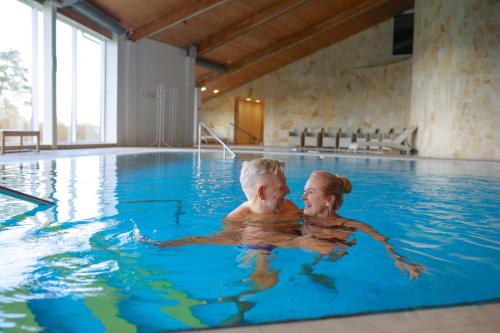 a man and woman in a swimming pool at Fra Mare Thalasso Spa in Haapsalu