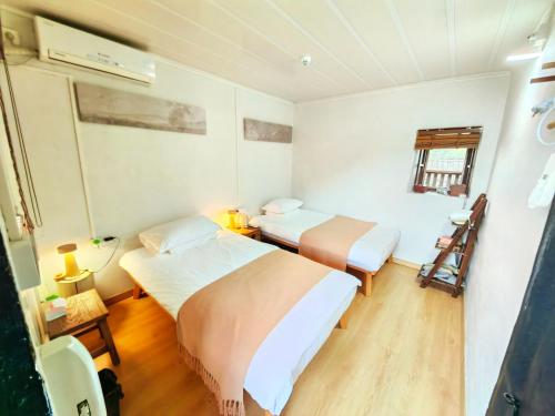 1 Schlafzimmer mit 2 Betten und einem Fenster in der Unterkunft Tulou Fuyulou Changdi Inn in Yongding