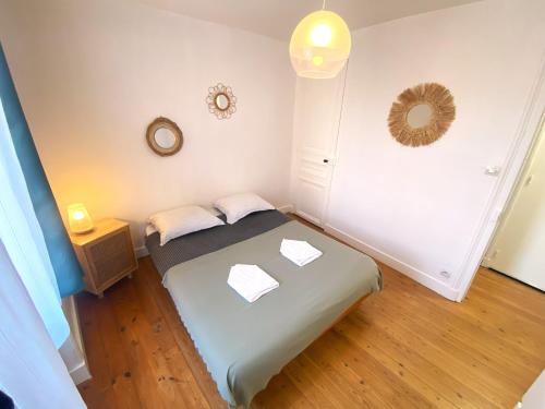 małą sypialnię z łóżkiem i lustrem w obiekcie Nacre - 400m de la mer - Juno Beach w mieście Bernières-sur-Mer