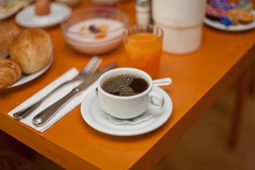 Hotel Alte Wache في هامبورغ: كوب من القهوة على طبق على طاولة