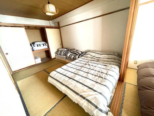 ein Schlafzimmer mit einem Bett in der Ecke eines Zimmers in der Unterkunft Ueda Building - Vacation STAY 8565 in Asahikawa