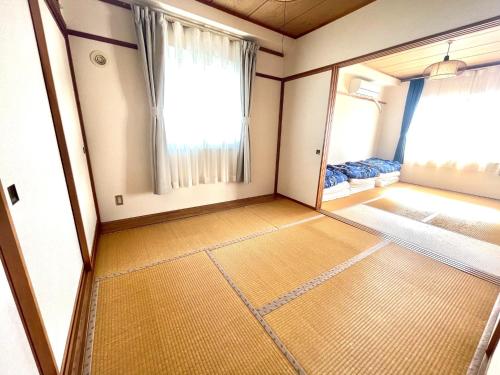 una piccola camera con una grande finestra e un piano di Ueda Building - Vacation STAY 8561 a Asahikawa