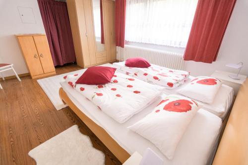 two beds in a room with red and white pillows at Ferienwohnung Richards in Idar-Oberstein