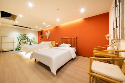 a room with four beds and an orange wall at September Hotel in Xi'an