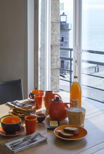 a table with plates of food and a bottle of juice at Chambres Breizh Café in Cancale