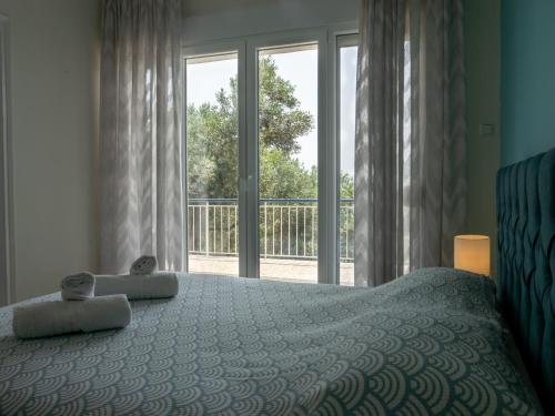 a bedroom with a bed and a large window at RHOMBUS by the sea in Paleo Tsifliki