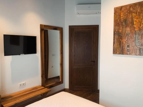 a bedroom with a mirror and a television on a wall at Casa Alegre Alaçatı in Alacati