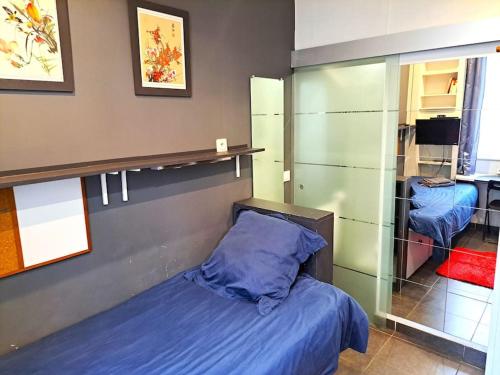 une chambre avec un lit et une paroi vitrée dans l'établissement Studette Chabaud Rue, à Reims