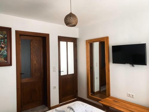 a room with two doors and a television on the wall at Casa Alegre Alaçatı in Alacati