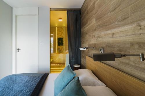 ein Schlafzimmer mit einem Bett mit einer Holzwand in der Unterkunft Apartamenty Homely Place 8 - Parking in Posen