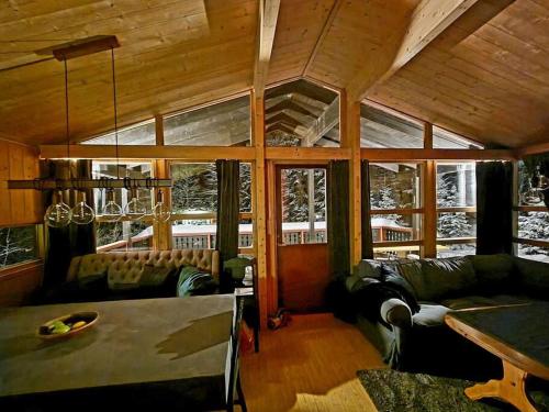 a living room with couches and a table and windows at Koselig fjellhytte i Trysil Ski & Turmuligheter in Trysil