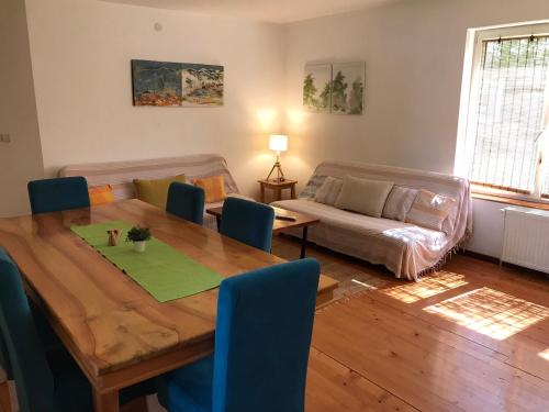 a living room with a wooden table and a couch at Garden's apartman - Kosjerić in Kosjerić