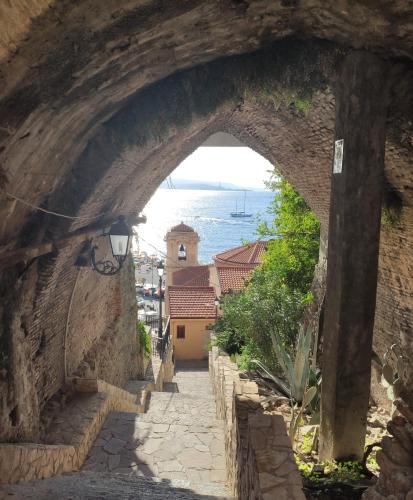 an archway in a stone wall with a view of the ocean at Stella Marina in Scilla