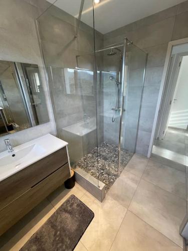 une salle de bain avec une douche et un lavabo et une perspective de douche dans l'établissement Rez de villa Machja vue mer et montagne à 2mn port, à Sari-Solenzara