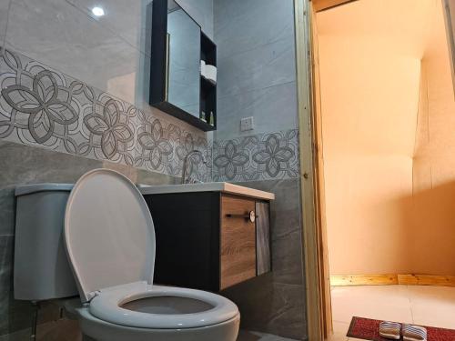 a bathroom with a toilet and a sink and a mirror at Salma Desert Camp in Wadi Rum