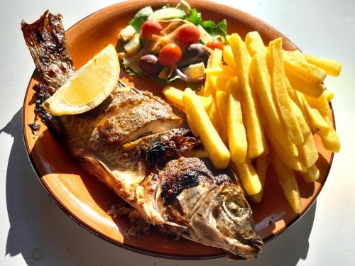 un plato de comida con pescado y patatas fritas en Crocodile Pools Resort, en Gaborone