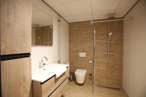 Un baño con ducha, lavabo e inodoro. en Long Stay Den Helder, en Den Helder