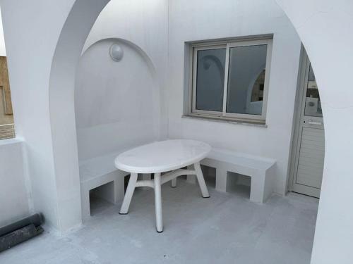a white table and a window in a white room at Le Dôme de Nabeul in Nabeul
