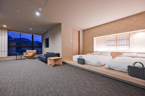 a bedroom with a large bed and a large window at Ureshino Onsen Yadoya Uchiroji in Ureshino