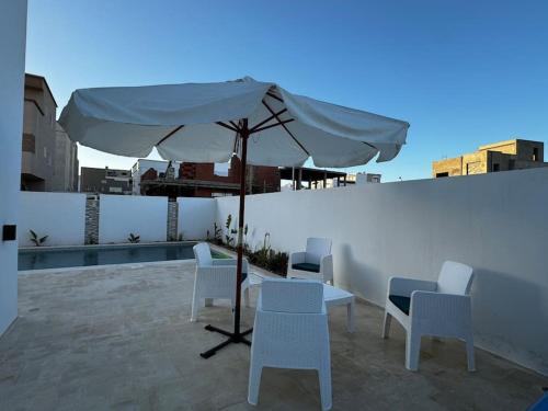 a table and chairs with an umbrella on a rooftop at Le Dôme de Nabeul in Nabeul