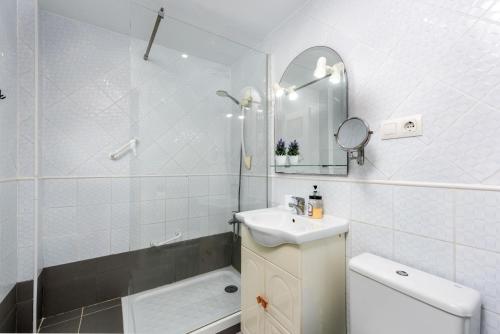 a bathroom with a sink and a toilet and a mirror at Manilva Home in San Luis de Sabinillas