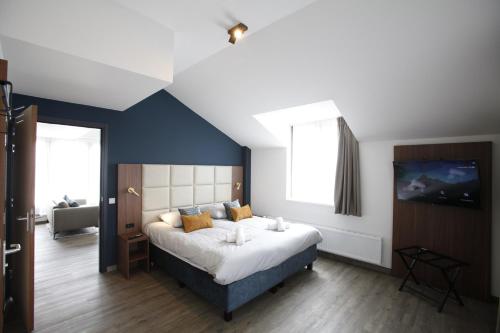 1 dormitorio con 1 cama grande y pared azul en Long Stay Den Helder, en Den Helder