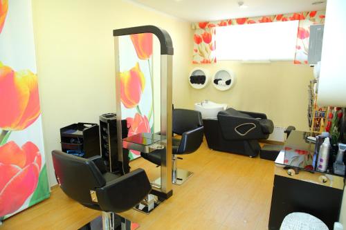 a salon room with a mirror and two chairs and a sink at Park Hotel Bishkek in Bishkek