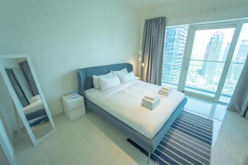 1 dormitorio con 1 cama y ventana grande en AWS Homes - Unique High View at Damac Heights, en Dubái