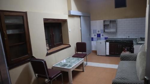a room with a table and chairs and a kitchen at Heranya Hostel in Kathmandu