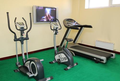 a gym with two exercise bikes and a tv at Park Hotel Bishkek in Bishkek