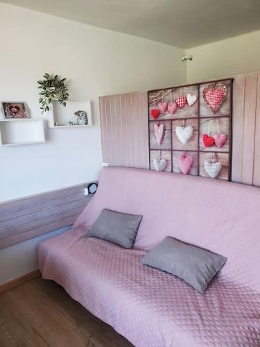 - une chambre avec un lit rose et 2 oreillers dans l'établissement Joli studio 4-6 pers - balcon avec vue sur montagne, à Saint-Étienne-en-Dévoluy