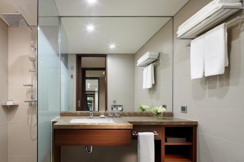a bathroom with a sink and a shower at LOTTE City Hotel Ulsan in Ulsan
