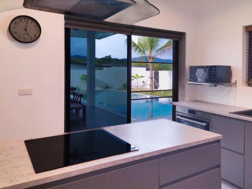 a kitchen with a counter with a clock on the wall at Villa et Bungalow Baan Joan Khao Lak in Khao Lak