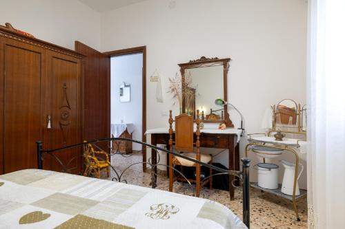 een slaapkamer met een bed, een bureau en een spiegel bij Villa Septis in Ostuni in Ostuni