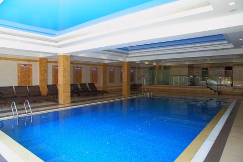 a large swimming pool in a hotel lobby at Park Hotel Bishkek in Bishkek