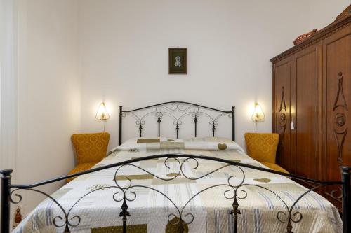 een slaapkamer met een groot bed en 2 stoelen bij Villa Septis in Ostuni in Ostuni