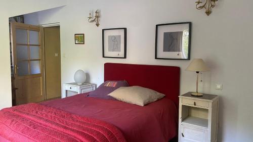 a bedroom with a red bed and two night stands at Paradis in Clohars-Carnoët