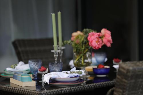 a table with plates and candles and flowers on it at Ferienwohnung Strandoase inklusive Terrasse und Parkplatz - Sonnenseite in Scharbeutz