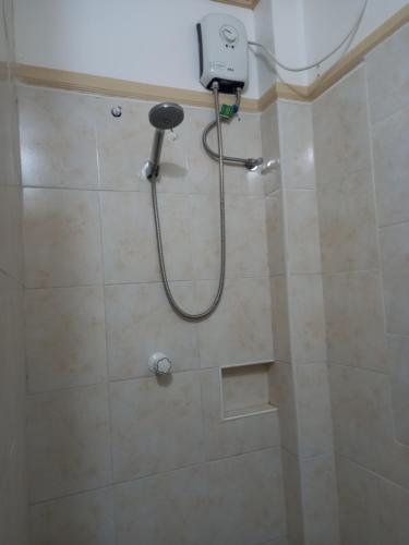a shower with a hose in a bathroom at Hill View Home Stay Bohol in Panglao
