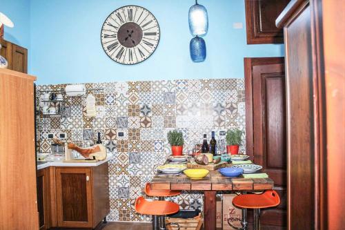 eine Küche mit einem Tisch und einer Uhr an der Wand in der Unterkunft Antica Cantina Emilia in Reggio di Calabria