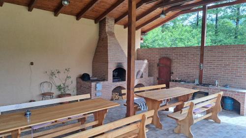 un patio con mesas de madera y un horno de ladrillo en Pensiunea Inima Daciei en Costeşti