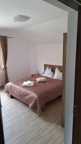 a bedroom with a bed in a white room at Pensiunea Inima Daciei in Costeşti